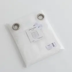 Verpakte helder witte Bibiana vitrage met matte roestvrij stalen ringen en Maroyathome-label op een witte ondergrond