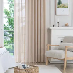 Beige Olivia vitrage tot op de vloer voor een openslaande deur in een lichte slaapkamer met houten fauteuil